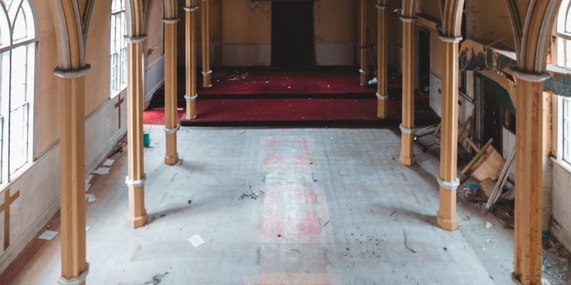 An empty gym space with natural light coming through windows.