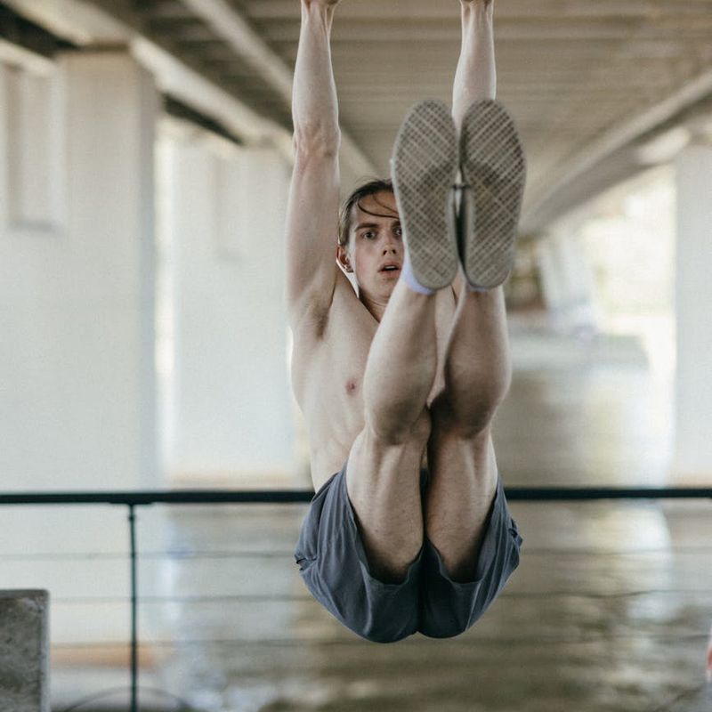 Man performing a controlled bodyweight exercise in a spacious loft.